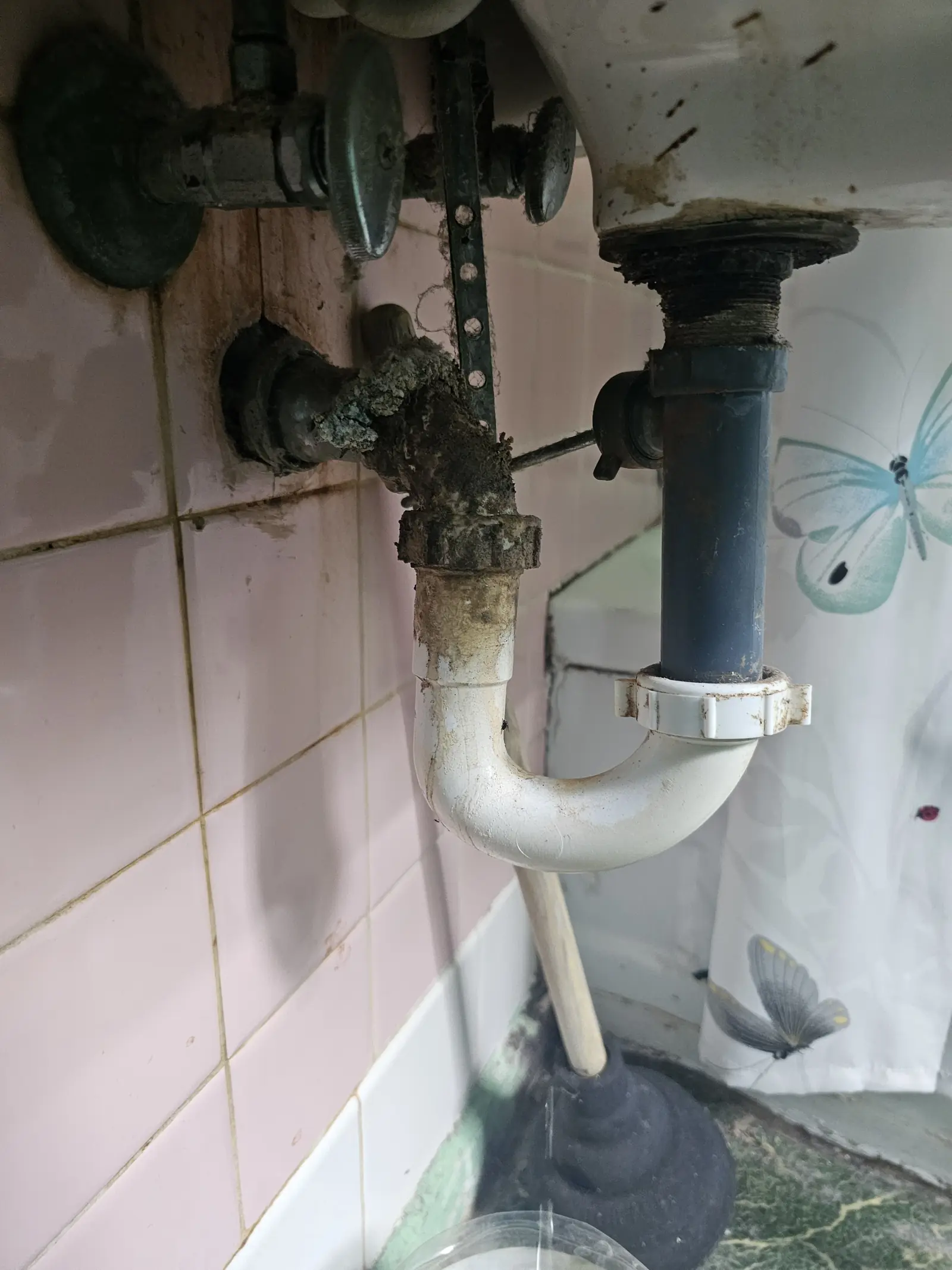 Corroded bathroom sink drain and old valves before repair