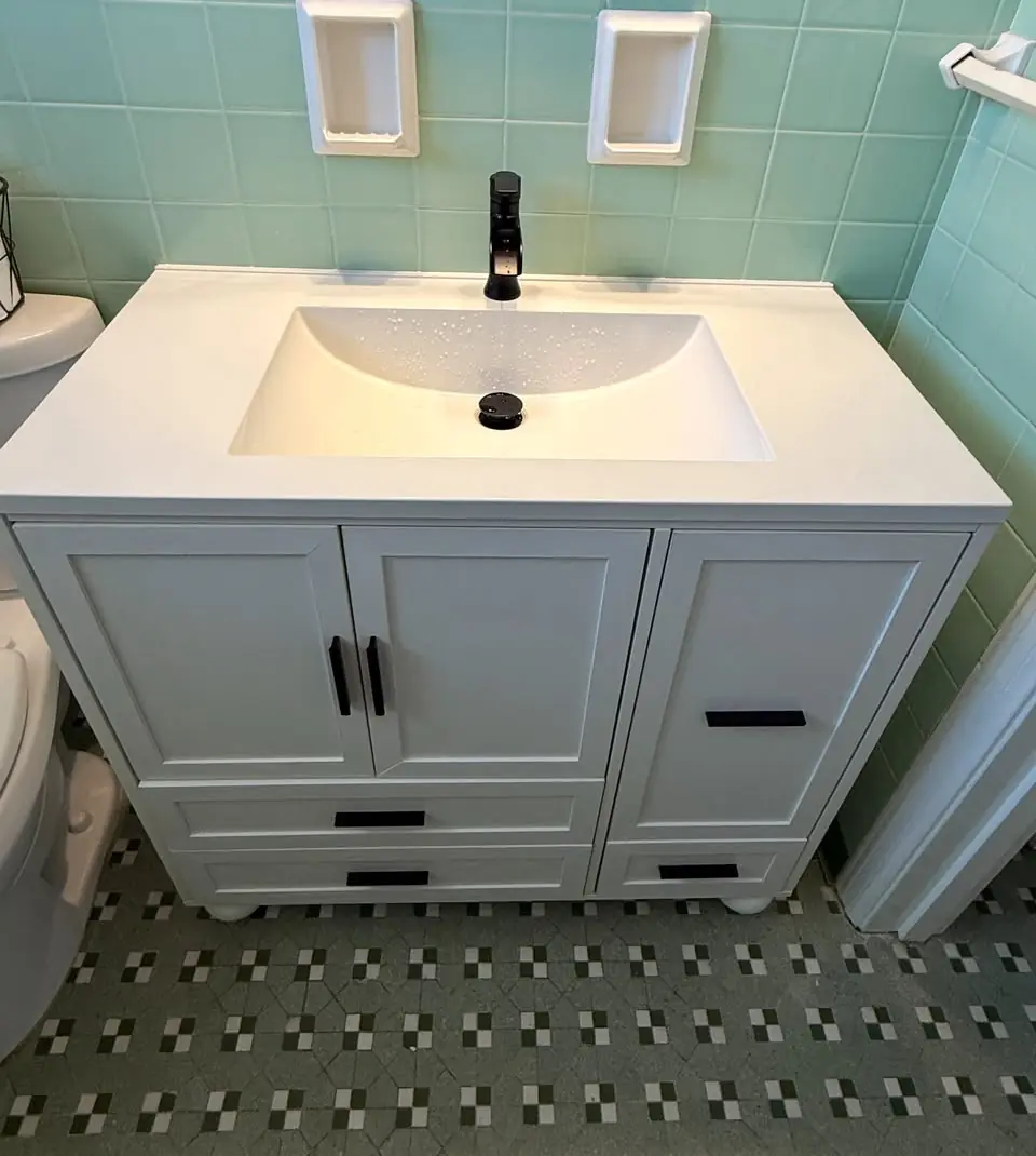Newly installed white bathroom vanity with matte black faucet in a Pensacola bathroom
