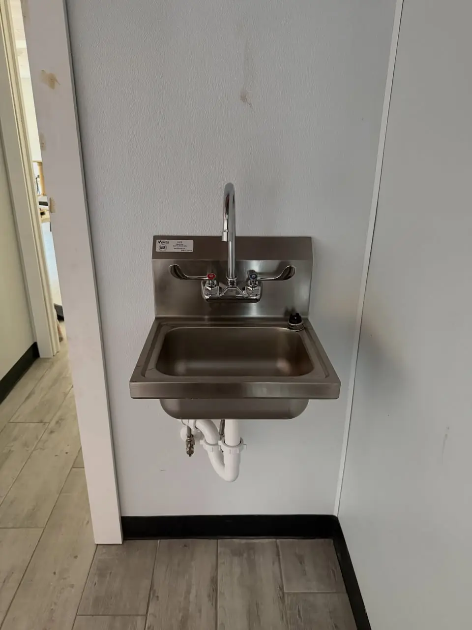 Stainless commercial hand sink installed on a wall