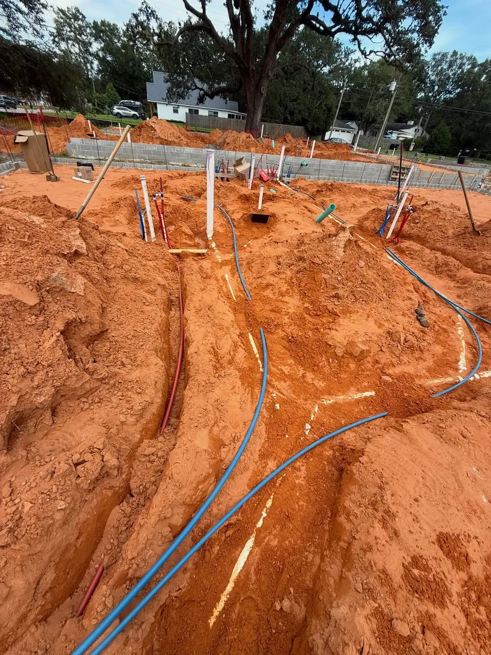 Plumbing stub-ups rising from the ground on a new construction lot