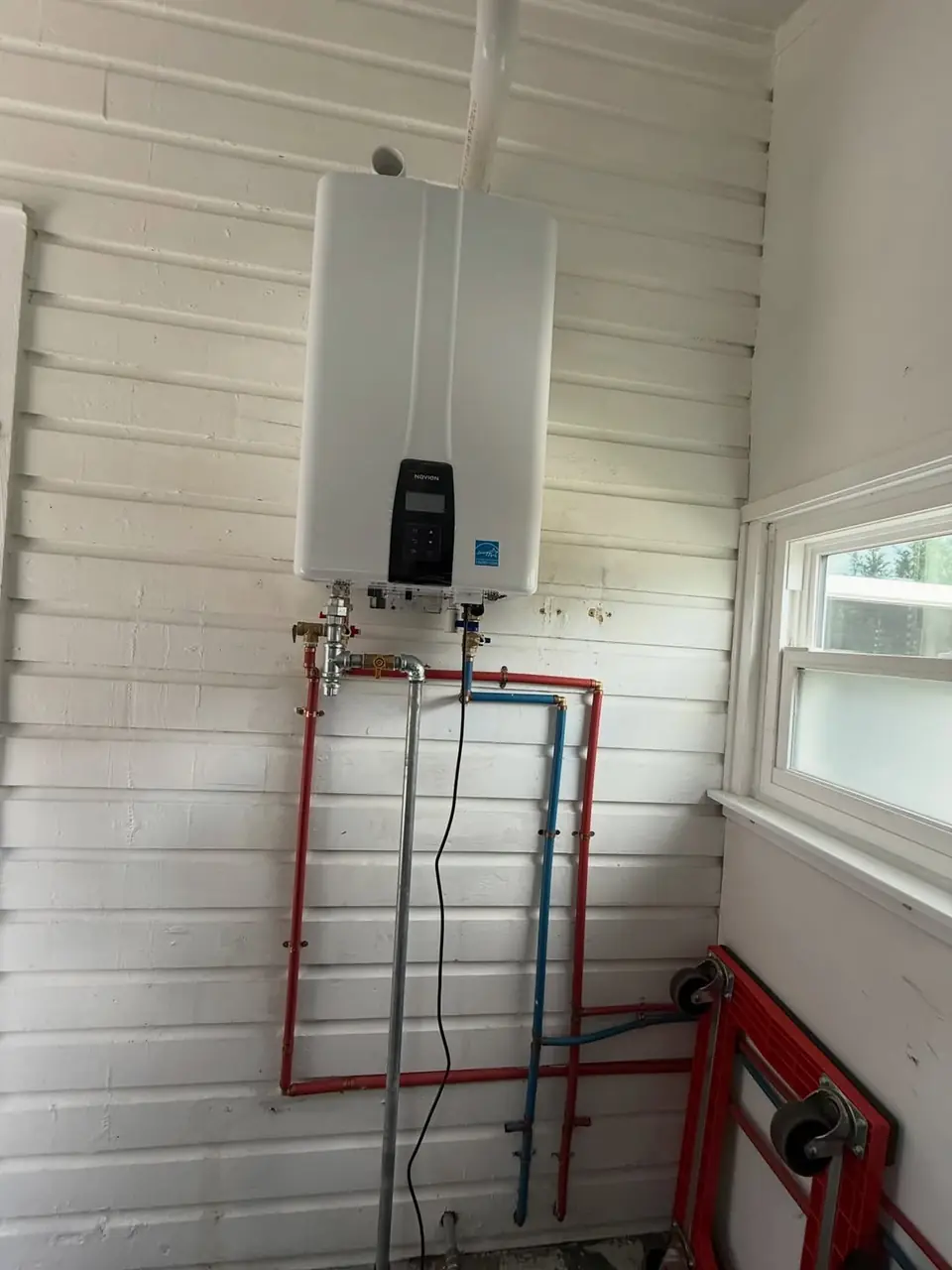 Wall-mounted tankless water heater installed by Aggressive Plumbing